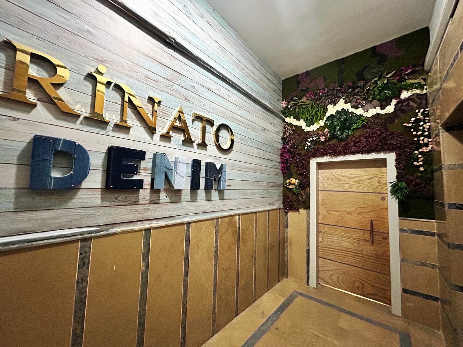 The entrance hall at Rinato's Bağcılar unit, with the Rinato Denim wall and the door to the office