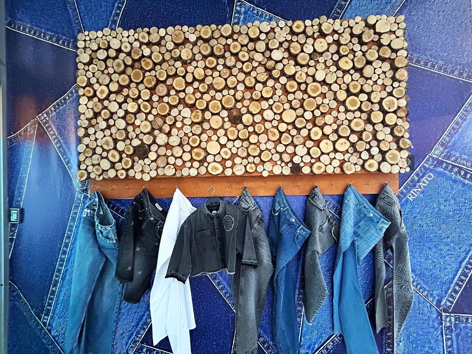 The denim wall in Rinato's showroom, with a season's samples on the rail beneath it